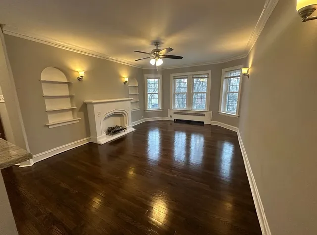 a view of empty room with fireplace and wooden floor