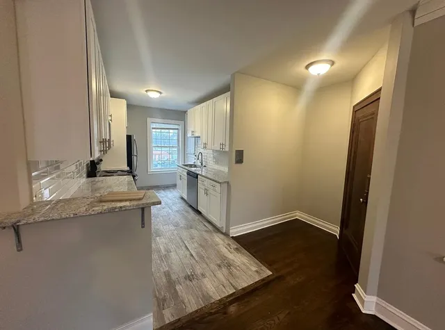 a kitchen with granite countertop a sink and refrigerator