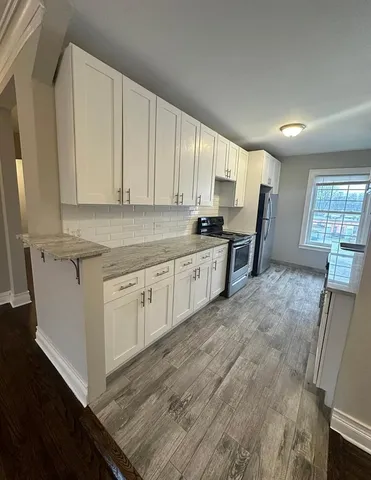 a kitchen with cabinets and wooden floor