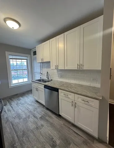 a kitchen with granite countertop white cabinets and white appliances