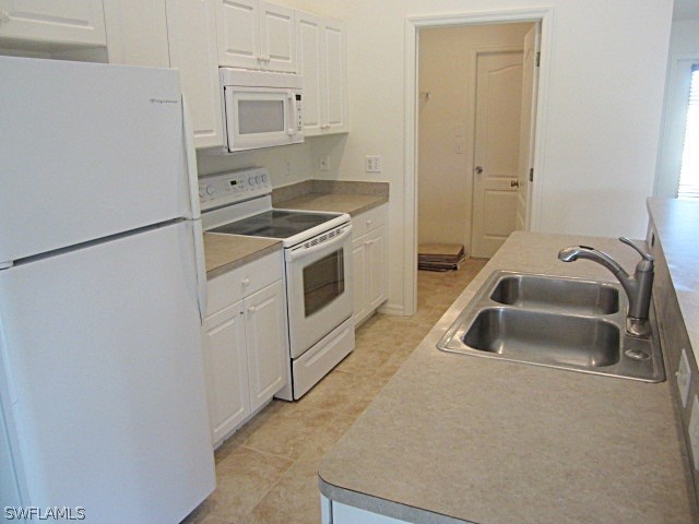 3717 Sunset Road Lehigh Acres, FL 33971 - Photo 8 of 11 a kitchen with a refrigerator and a sink