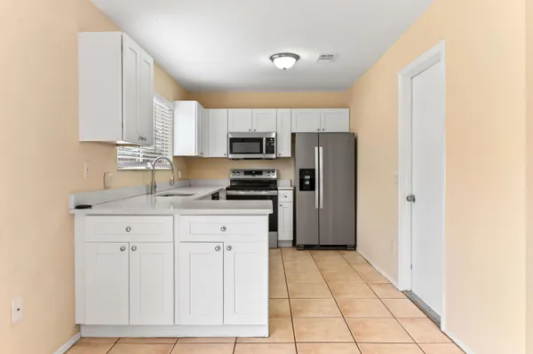 a kitchen with stainless steel appliances granite countertop a refrigerator sink and cabinets