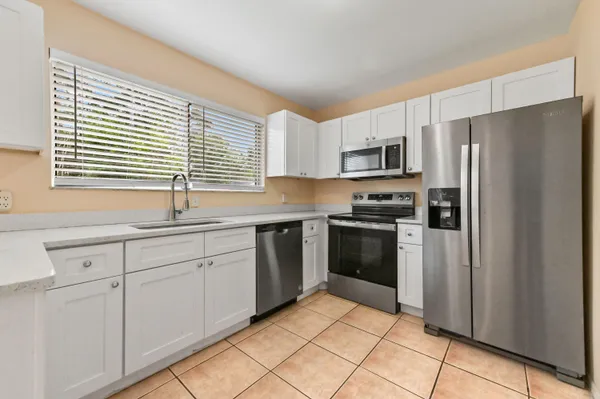 a kitchen with granite countertop a refrigerator and a sink
