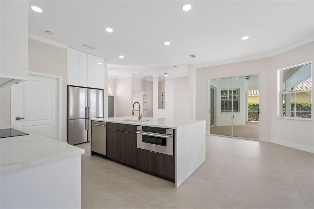 629 Sawgrass Bridge Road Venice, FL 34292 - Photo 11 of 36 a kitchen with stainless steel appliances kitchen island granite countertop a stove and a refrigerator