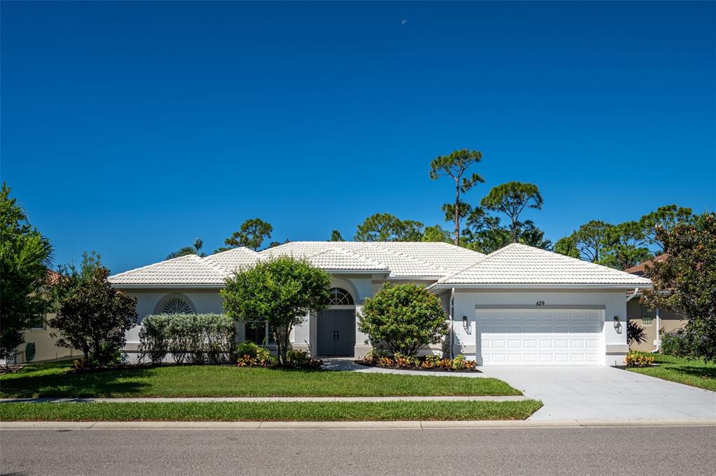 629 Sawgrass Bridge Road Venice, FL 34292 - Photo 2 of 36 a front view of a house with a garden and trees