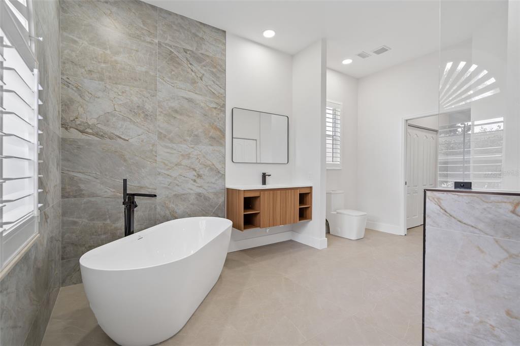 629 Sawgrass Bridge Road Venice, FL 34292 - Photo 21 of 36 a bathroom with a white tub shower sink and mirror