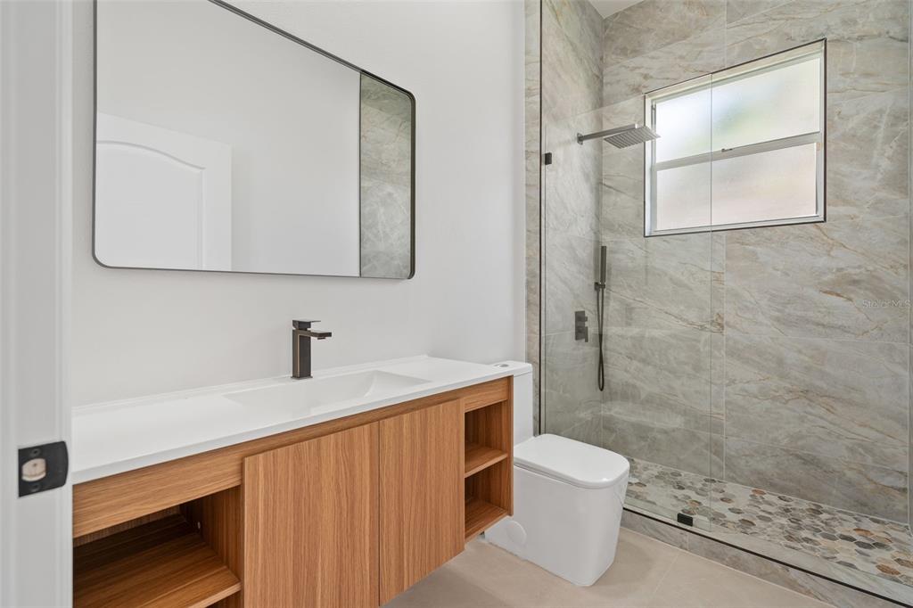 629 Sawgrass Bridge Road Venice, FL 34292 - Photo 26 of 36 a bathroom with a granite countertop sink toilet a mirror and shower