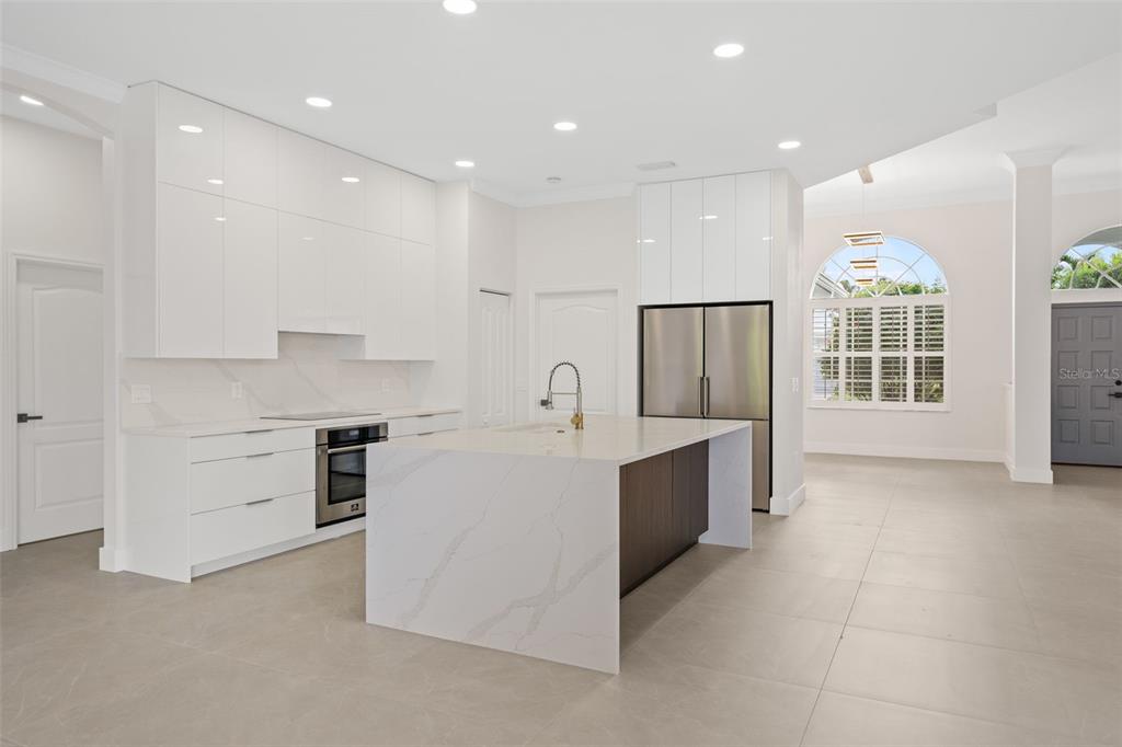 629 Sawgrass Bridge Road Venice, FL 34292 - Photo 6 of 36 a large white kitchen with a stove a sink a refrigerator and a cabinets