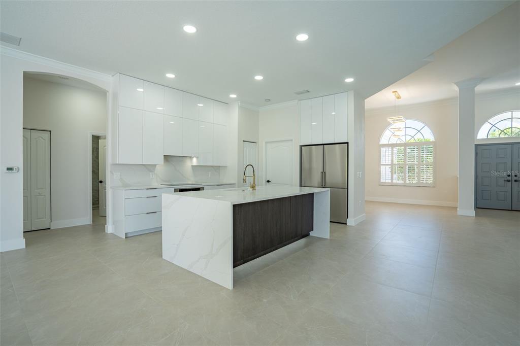 629 Sawgrass Bridge Road Venice, FL 34292 - Photo 8 of 36 a large kitchen with stainless steel appliances a large counter top a stove and a refrigerator