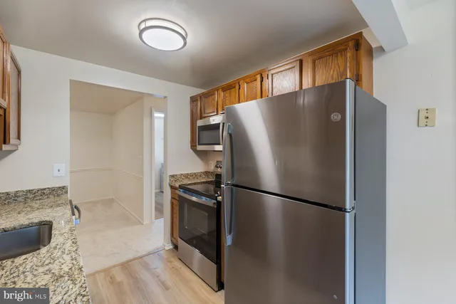 a metallic refrigerator freezer sitting in a kitchen