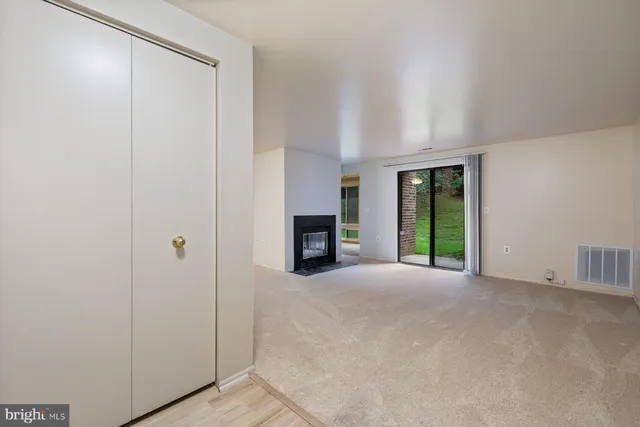 a view of an empty room with a window and a fireplace