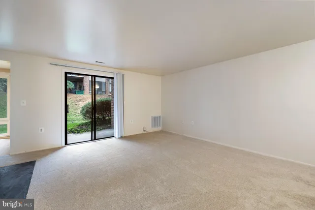 an empty room with sliding door and balcony view