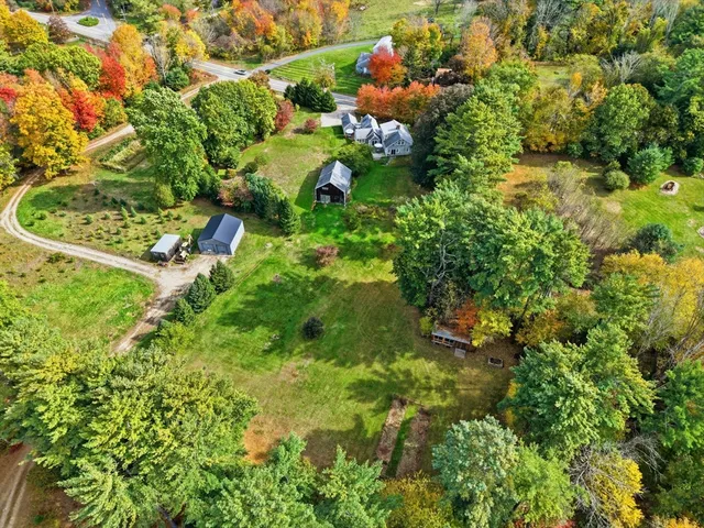 an aerial view of residential house with yard and outdoor seating