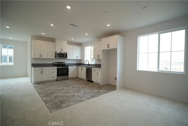 a large kitchen with stainless steel appliances granite countertop a stove and a refrigerator