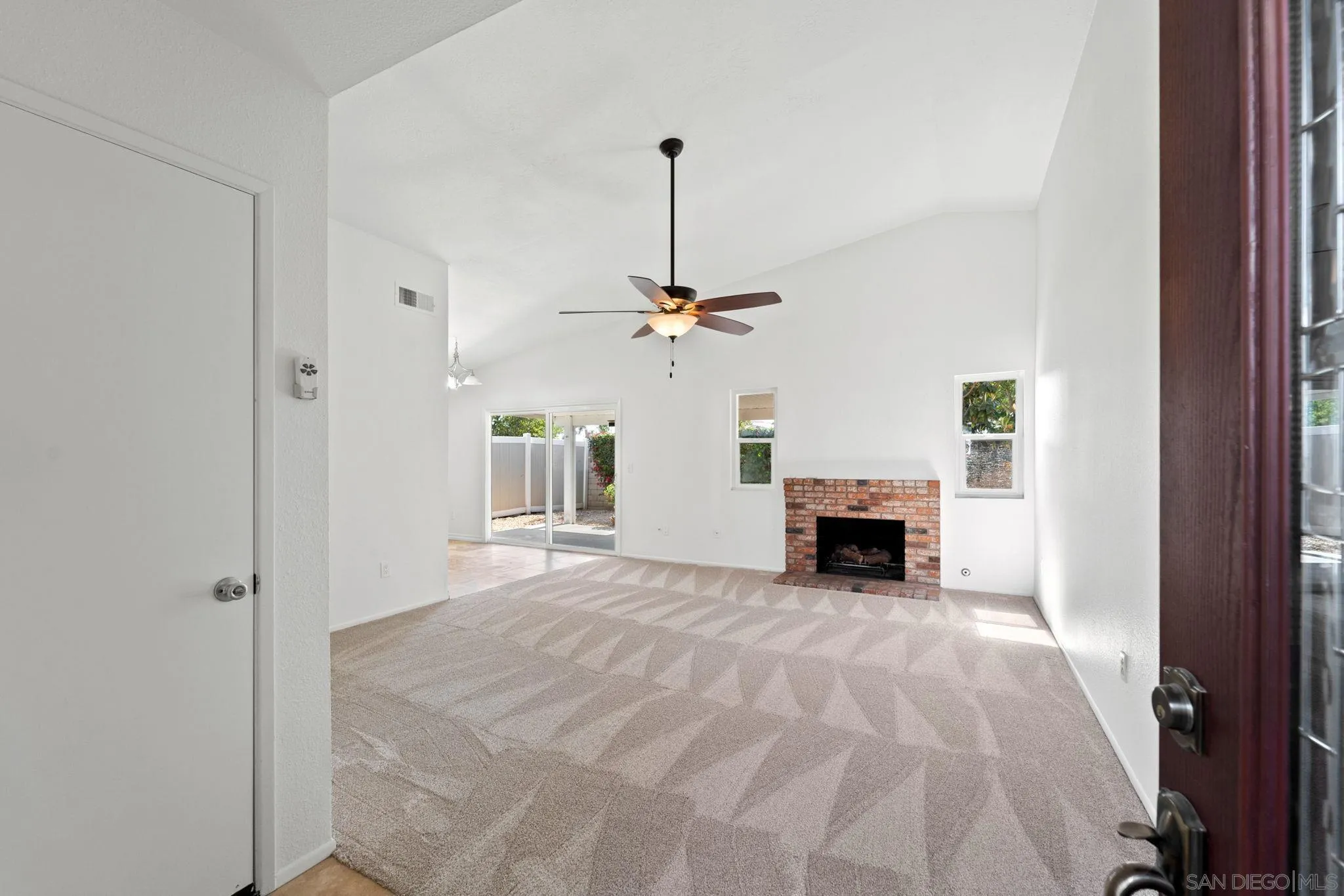 10174 West Glendon Circle Santee, CA 92071 - Photo 27 of 41 a view of a livingroom with a fireplace a chandelier and windows