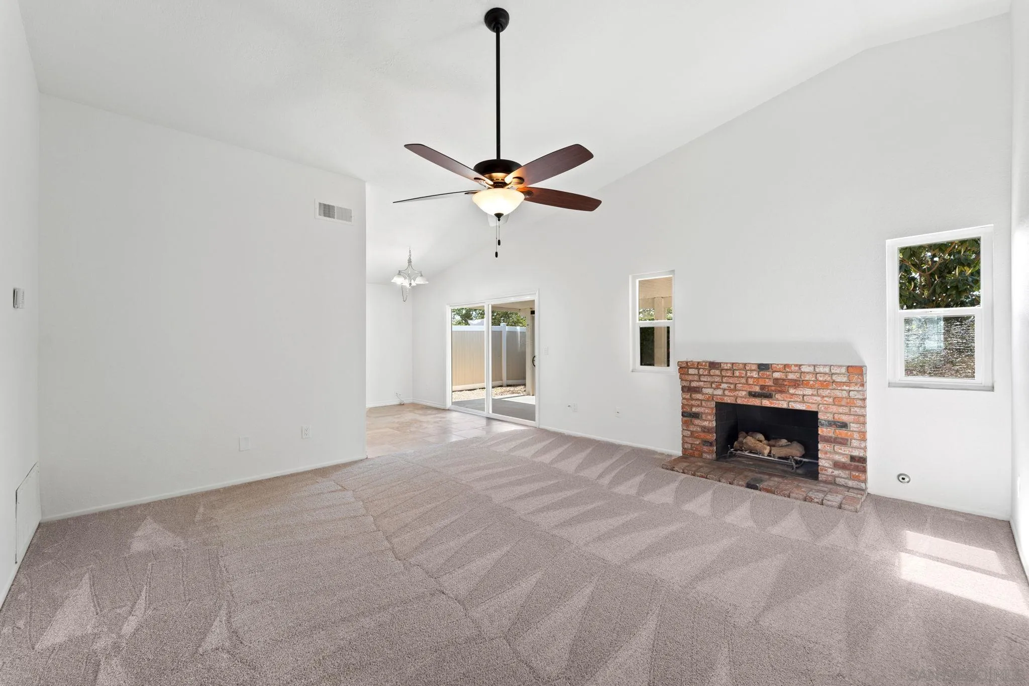 10174 West Glendon Circle Santee, CA 92071 - Photo 3 of 41 a view of an empty room with fireplace and a chandelier fan