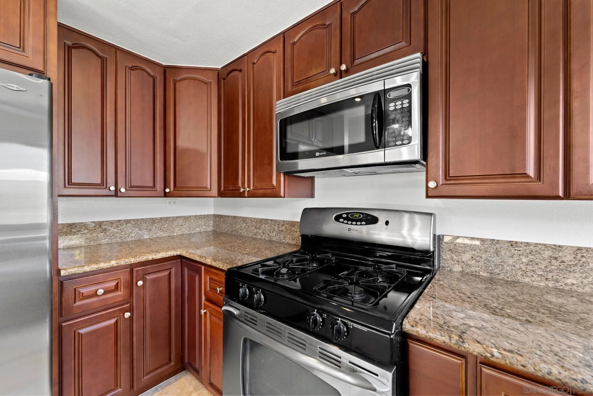 10174 West Glendon Circle Santee, CA 92071 - Photo 34 of 41 a kitchen with granite countertop a stove and a microwave
