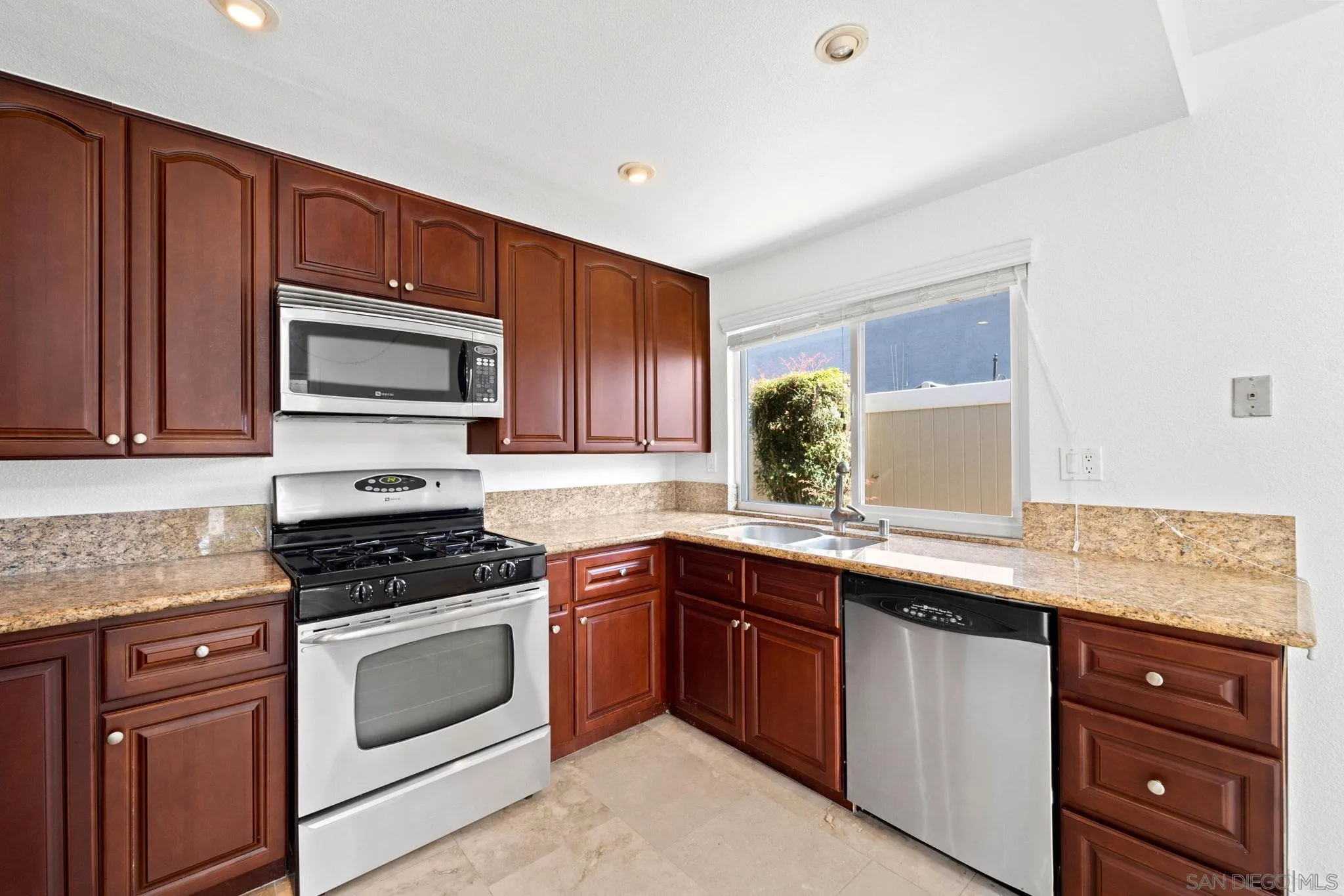 10174 West Glendon Circle Santee, CA 92071 - Photo 8 of 41 a kitchen with stainless steel appliances granite countertop wooden cabinets and a stove top oven