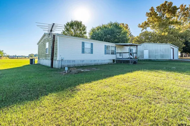 a view of a house with backyard and garden
