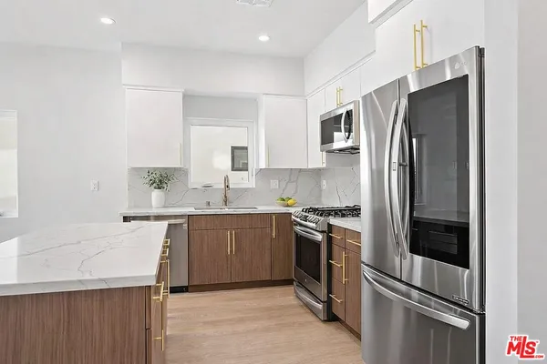 a kitchen with stainless steel appliances granite countertop a refrigerator stove and sink