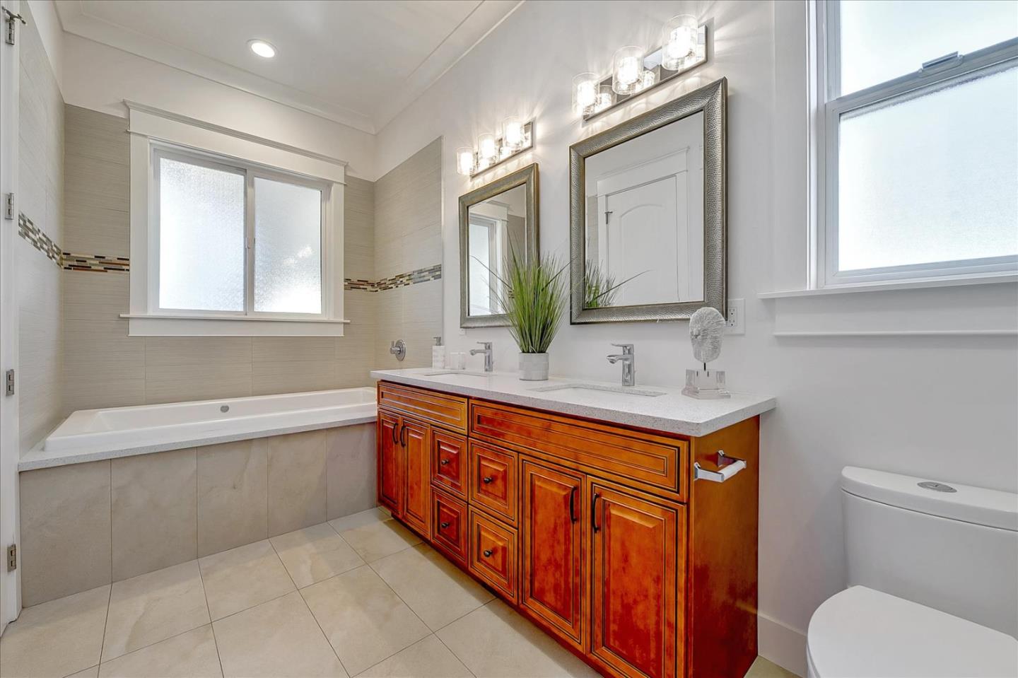 10380 Sterling Boulevard Cupertino, CA 95014 - Photo 38 of 49 a bathroom with a granite countertop double vanity sink a mirror and a bathtub
