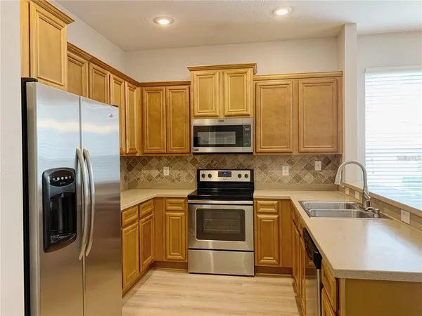 a kitchen with stainless steel appliances granite countertop a refrigerator stove and sink