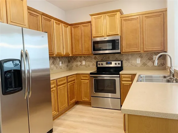 a kitchen with stainless steel appliances granite countertop a refrigerator stove and microwave