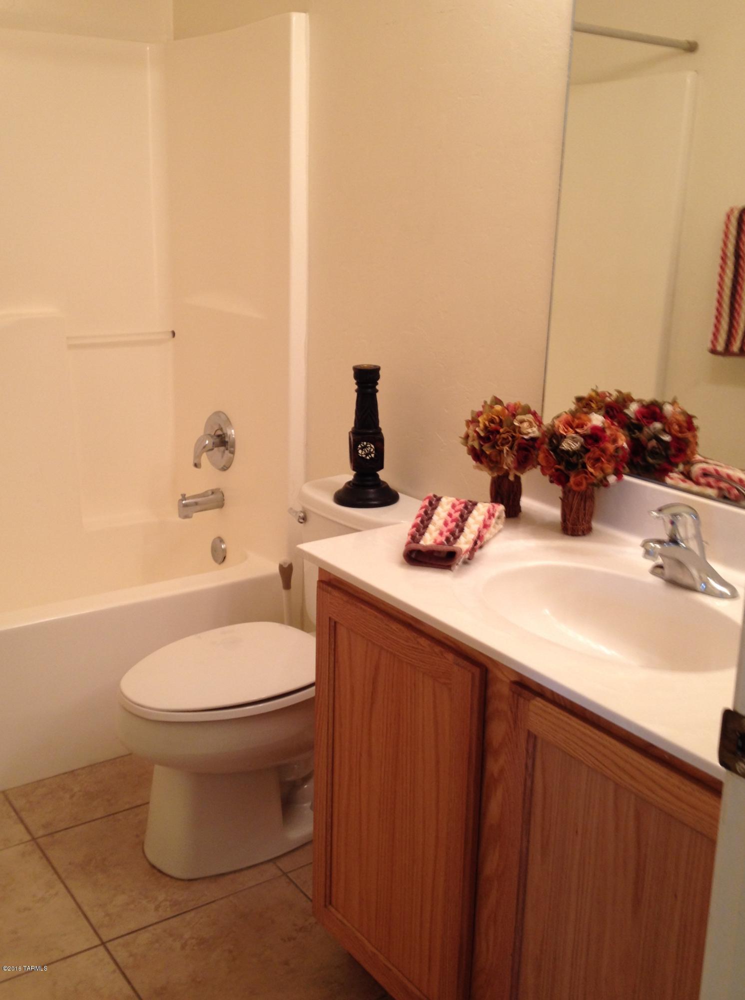 7931 North Iron Ridge Drive Tucson, AZ 85743 - Photo 12 of 21 a bathroom with a sink a toilet and mirror