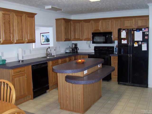 222 Robertson Road Roxboro, NC 27574 - Photo 2 of 10 a kitchen with stainless steel appliances granite countertop a sink a stove and a refrigerator