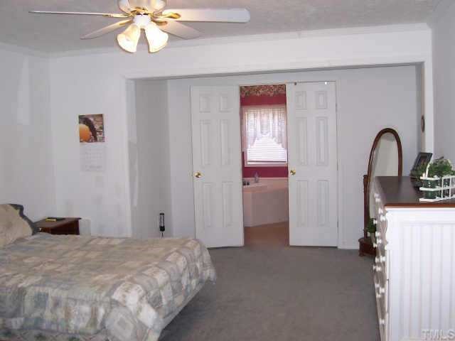 222 Robertson Road Roxboro, NC 27574 - Photo 4 of 10 a bedroom with a bed and a chandelier