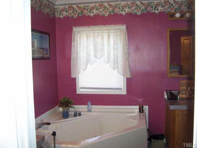 222 Robertson Road Roxboro, NC 27574 - Photo 5 of 10 a bathroom with a bathtub and a window