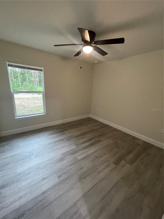 10631 North Frantz Avenue Citrus Springs, FL 34434 - Photo 13 of 21 an empty room with wooden floor fan and windows