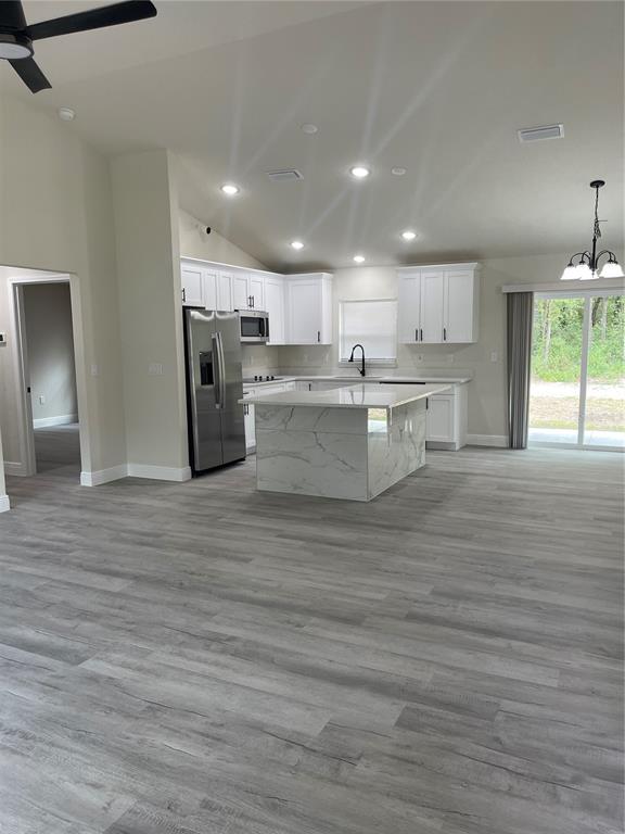 10631 North Frantz Avenue Citrus Springs, FL 34434 - Photo 3 of 21 a open kitchen with kitchen island a sink stove and a refrigerator