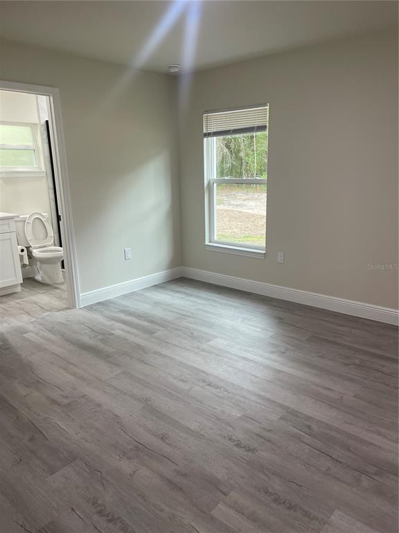 10631 North Frantz Avenue Citrus Springs, FL 34434 - Photo 8 of 21 a view of an empty room with wooden floor and a window