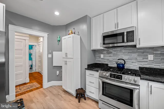 a kitchen with stainless steel appliances granite countertop a stove a refrigerator and a microwave