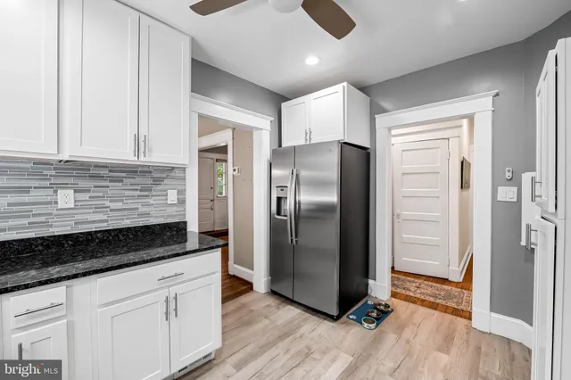 a kitchen with a refrigerator and a stove top oven