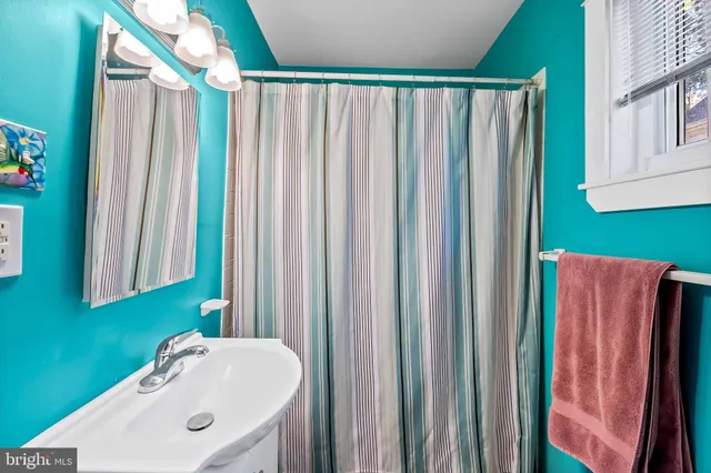 a bathroom with a sink a mirror and a shower curtain