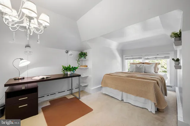 a bedroom with a bed and a lamp on dresser