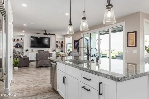 a large kitchen with granite countertop a large counter top appliances and cabinets