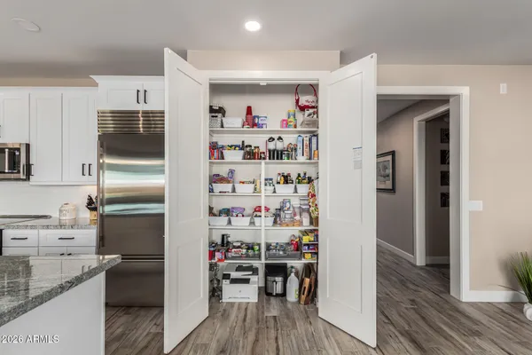 a kitchen with a refrigerator and wooden floor