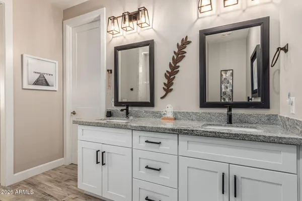 a bathroom with a granite countertop sink vanity and mirror