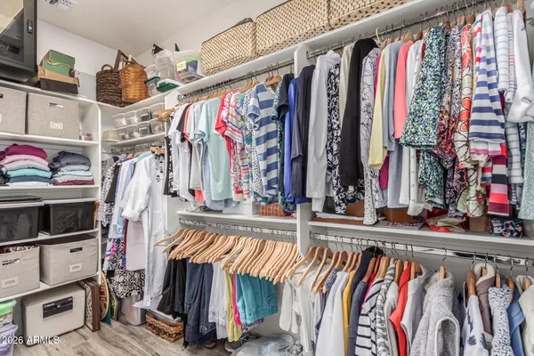a view of walk in closet with clothes and shoes