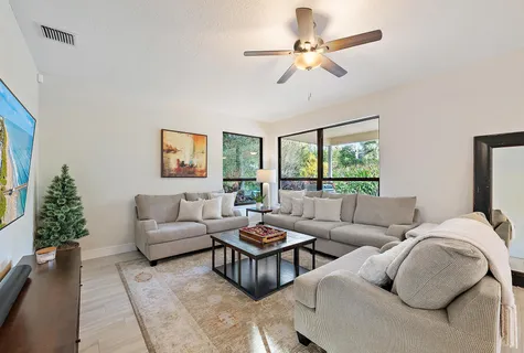 a living room with furniture ceiling fan and a window