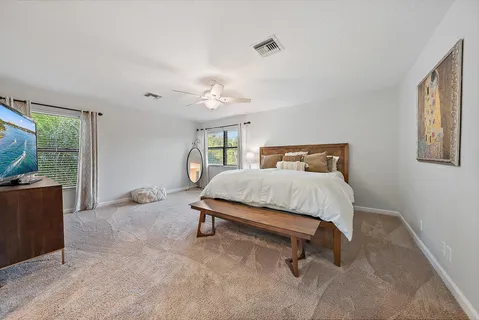 a spacious bedroom with a bed and a chandelier