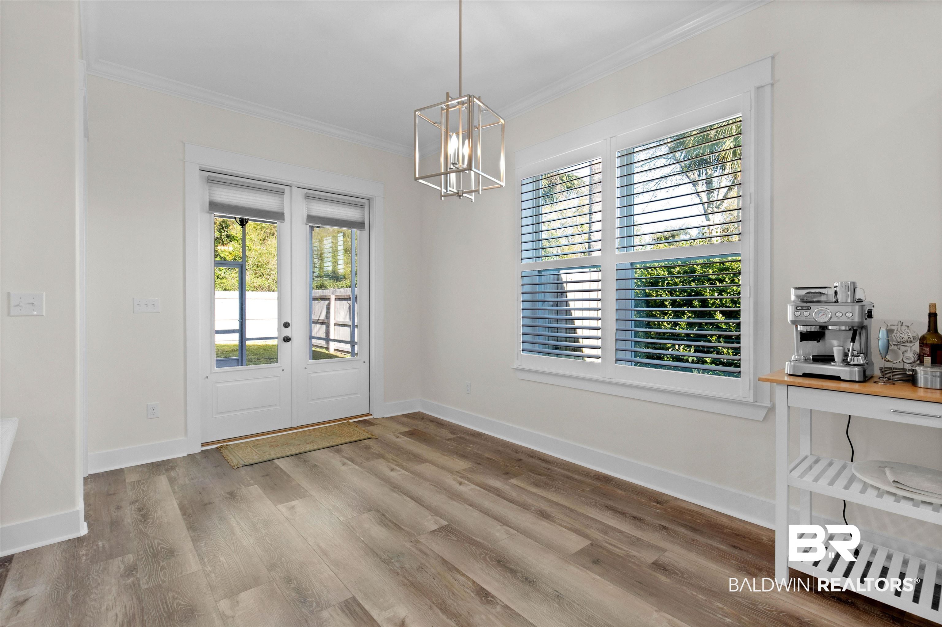 8069 Carmel Circle Foley, AL 36535 - Photo 9 of 23 Unfurnished dining area with ornamental molding, baseboards, a chandelier, and wood finished floors