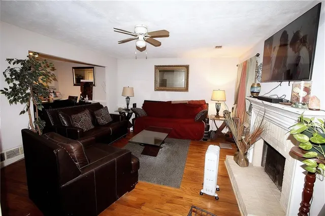 a living room with furniture a flat screen tv and a fireplace