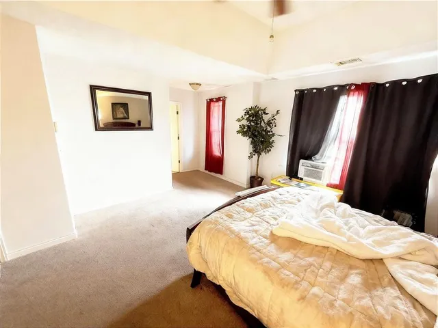 a bedroom with a bed dresser and a flat tv screen