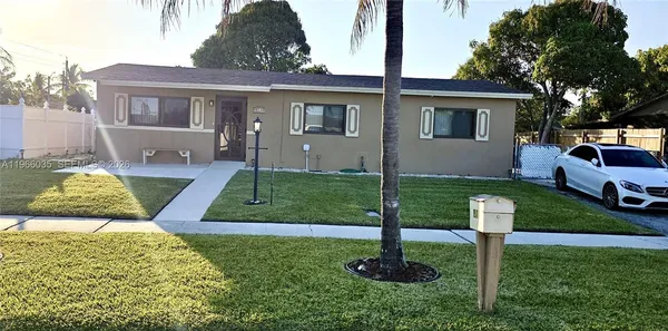 a front view of a house with a garden and trees