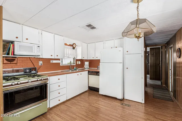 a kitchen with stainless steel appliances a stove a refrigerator and white cabinets