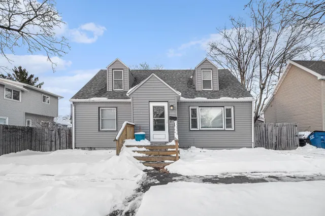 a front view of a house with a yard covered in snow
